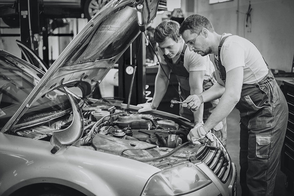 Two mechanics inspecting a car engine